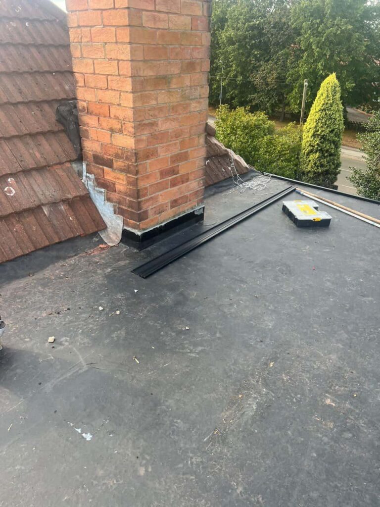 This is a photo of a flat roof which has just been repaired, there is also a chimney stack and some leadwork has also been dressed. Works carried out by Cannock Roofing Repairs